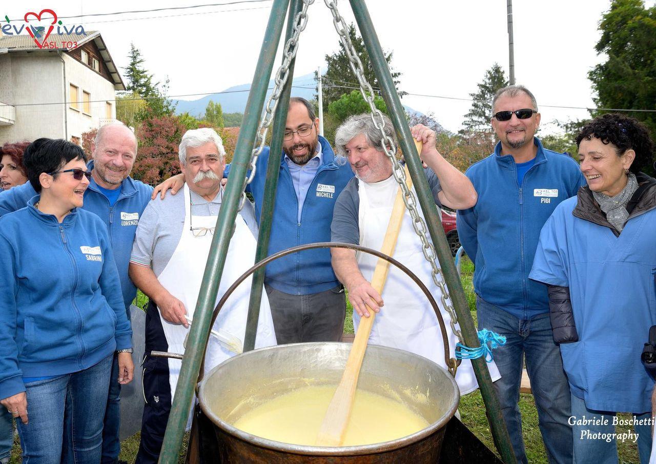 Volontari che preparano la polenta per la comunità durante una festa in piazza