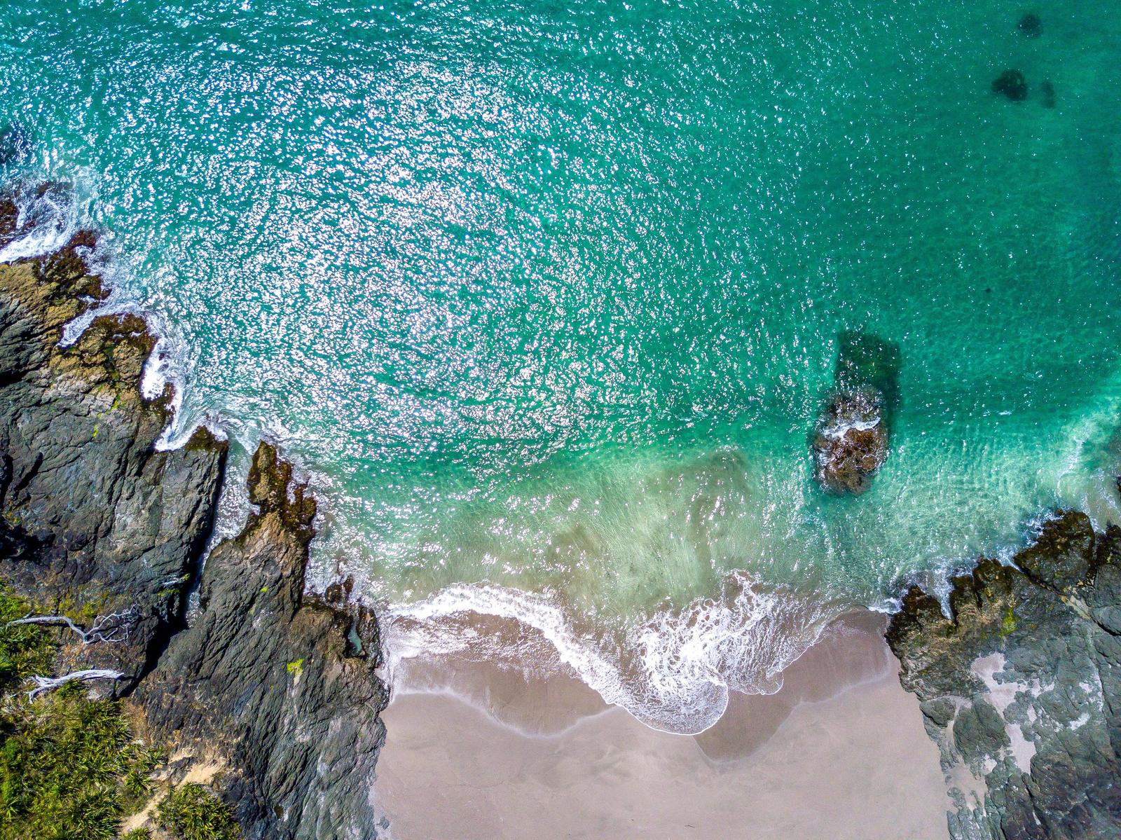 Veduta aerea di una spiaggia con acqua turchese e scogli